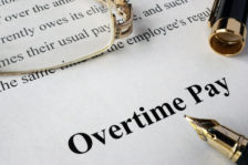 Picture of overtime pay document with pin and glasses.